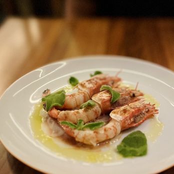 Corrida signature dishes Txuleton (Basque-style bone-in ribeye steak), Gambas al Ajillo, Patatas Bravas, Selection of Conservas (tinned seafood)